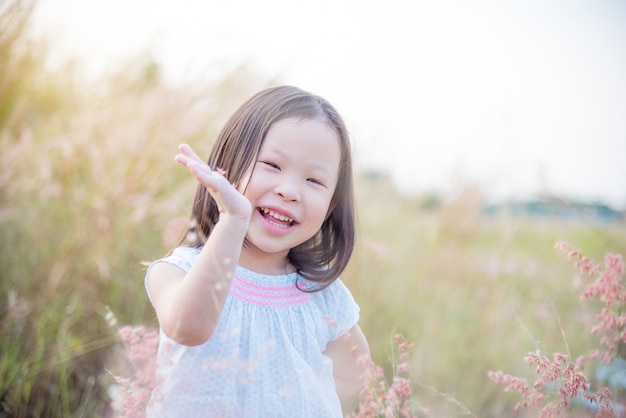 Niña asiática sonriendo en campo de hierba