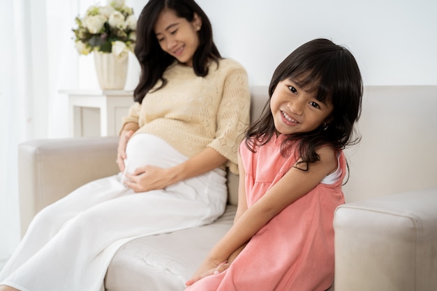 Niña asiática sonriendo cuando se sientan en el sofá