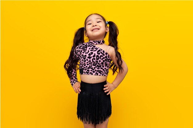 niña asiática vestida de baile baila chachacha sobre fondo amarillo aislado bailarina infantil coreana