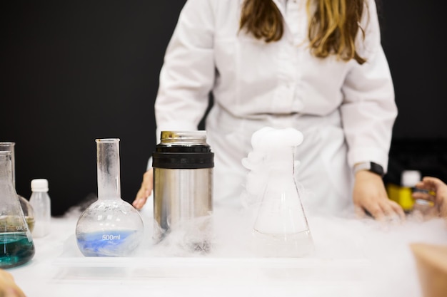 Una niña asistente de laboratorio realiza un experimento de laboratorio.