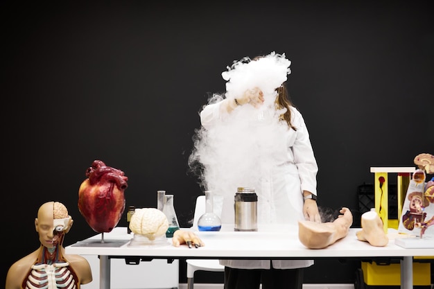 Una niña asistente de laboratorio realiza un experimento de laboratorio.