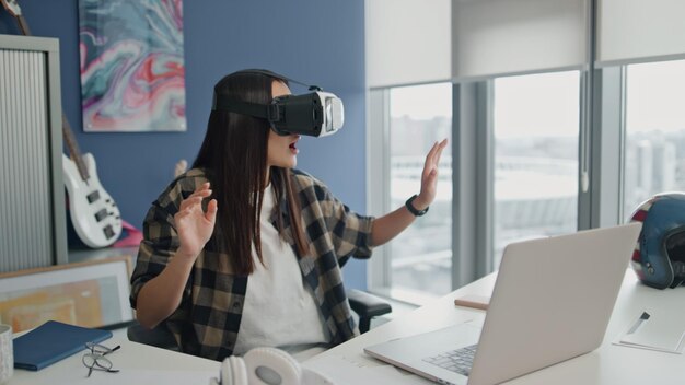 Niña asombrada explorando el espacio en la oficina en primer plano intentando un juego virtual