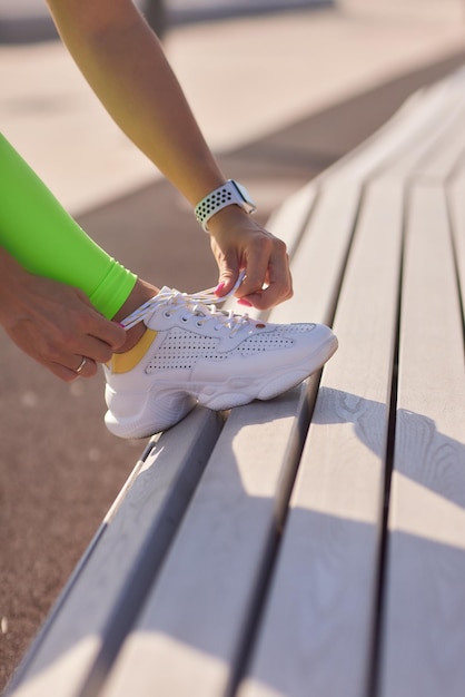 Niña atando cordones en zapatos blancos antes de correr el concepto de deporte