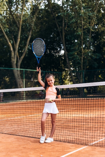 Niña en ropa está jugando tenis | Foto Premium