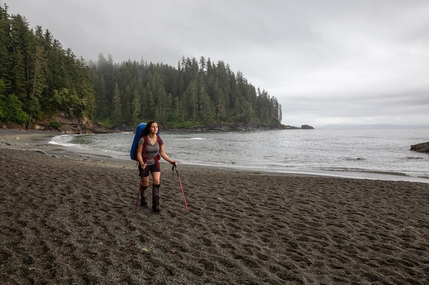 Niña aventurera caminando por el sendero Juan de Fuca hasta la playa de Sombrio en la costa del Océano Pacífico