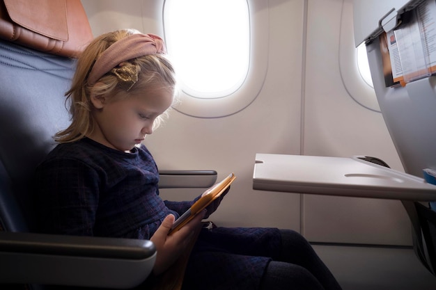 Niña en avión con tablet