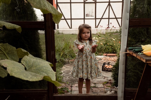 Niña ayudando a Moher a trabajar en el invernadero del jardín de su casa