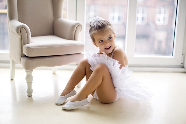 Niña bailarina de 2 años en el estudio con un vestido de tutú blanco