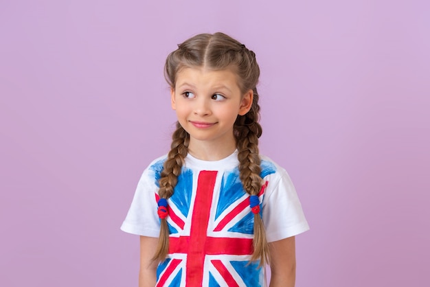 Una niña con una bandera inglesa en su camiseta mira hacia otro lado.