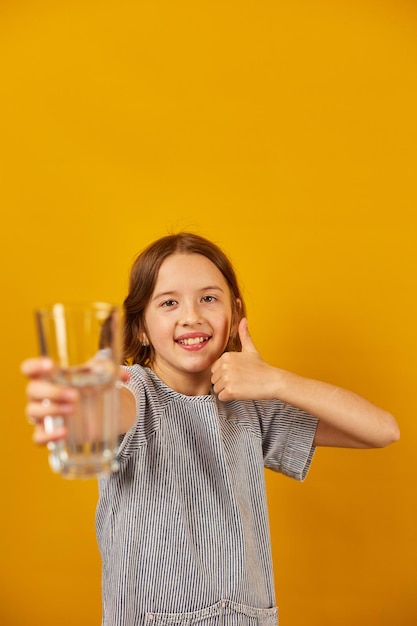 Foto niña bastante adolescente con un vaso de agua fresca aislado