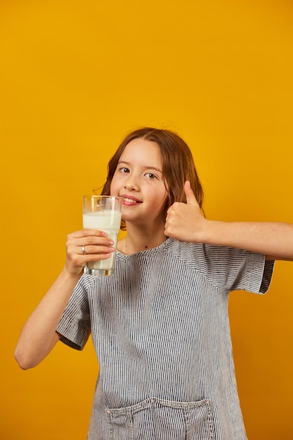 Niña bastante adolescente con un vaso de leche fresca