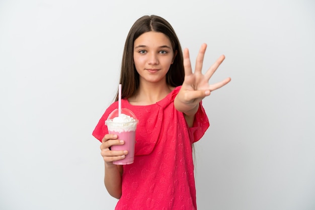 Niña con batido de fresa sobre fondo blanco aislado feliz y contando cuatro con los dedos