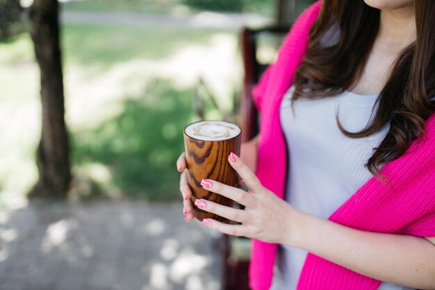 La niña bebe café Chica sosteniendo café en sus manos Delicioso capuchino en manos de una niña Café y capuchino en mano Buenos días Delicioso café