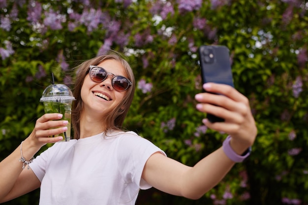 Niña bebe un refrescante cóctel contra el cielo