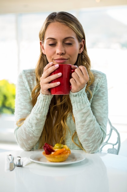 Niña bebe su café y cierra los ojos.