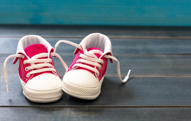 Niña bebé zapatos rosados en fondo de color azul vista de primer plano