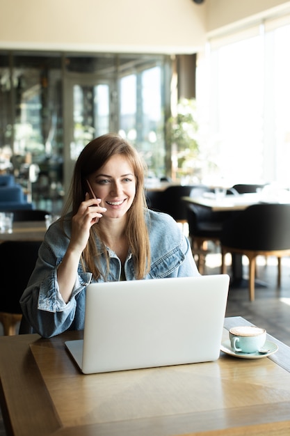 Niña bebiendo café y hablando por teléfono