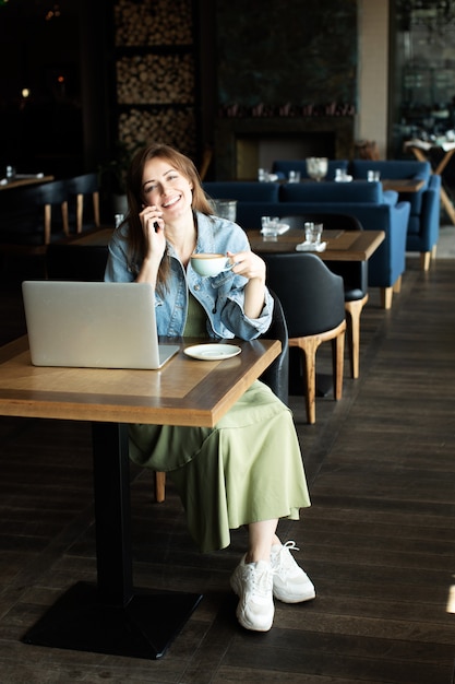 Niña bebiendo café y hablando por teléfono