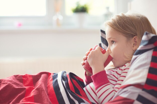 Foto niña bebiendo café mientras se relaja en casa