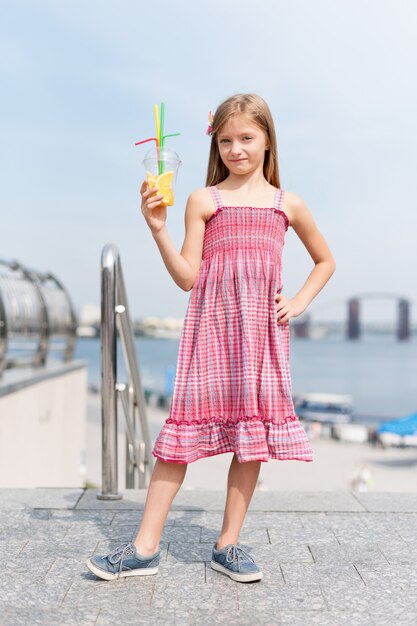 Niña bebiendo cócteles de frutas al aire libre