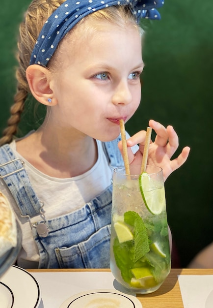 Niña bebiendo mojito sin alcohol en un café