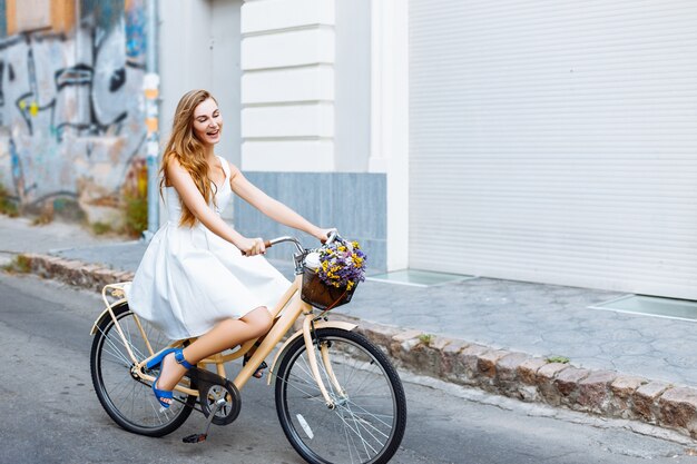 La niña va en bicicleta por la calle.