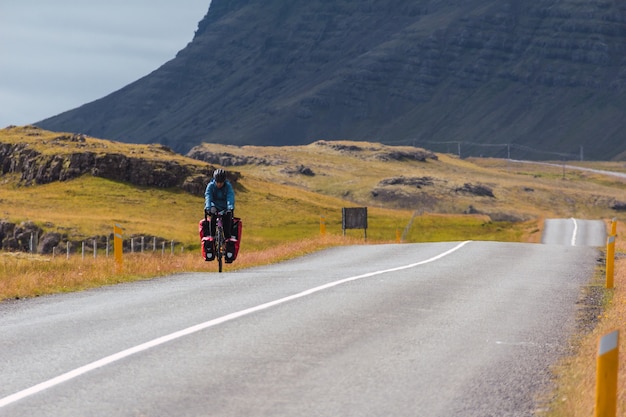 Niña en bicicleta por una carretera pavimentada en Islandia.