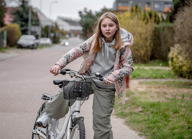 Niña en bicicleta entre casas privadas en Europa durante la primavera