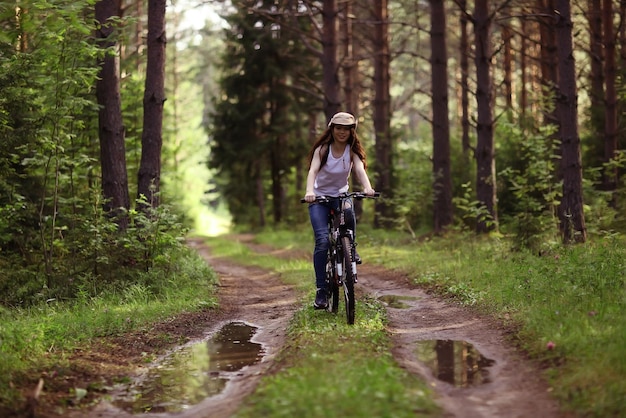 niña en una bicicleta deportiva en un bosque de verano