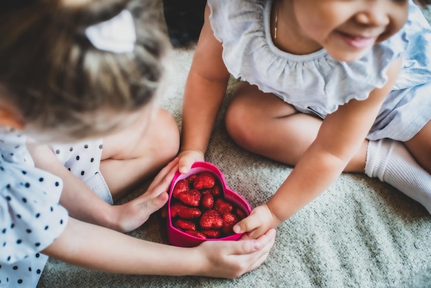 Una niña en blanco y negro jugando en la habitación bebé afroamericano y europeo sentado en el sofá