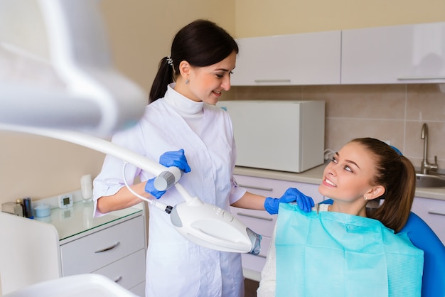 Una niña blanquea sus dientes en odontología.