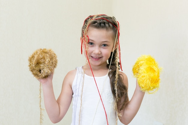 Una niña con bolas de hilo para tejer.