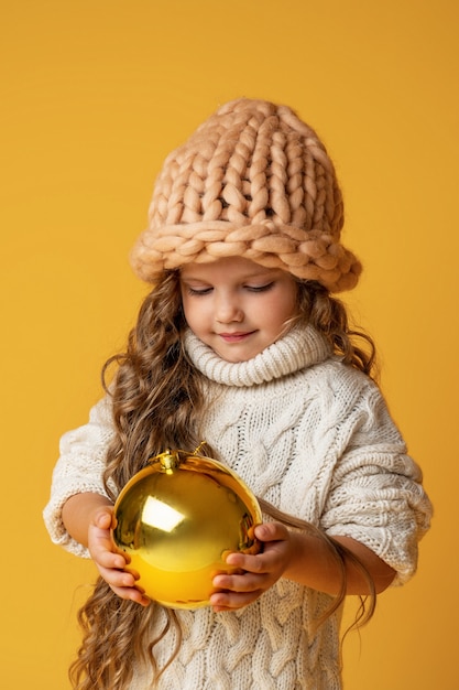 Foto niña con bolas de navidad en sus manos