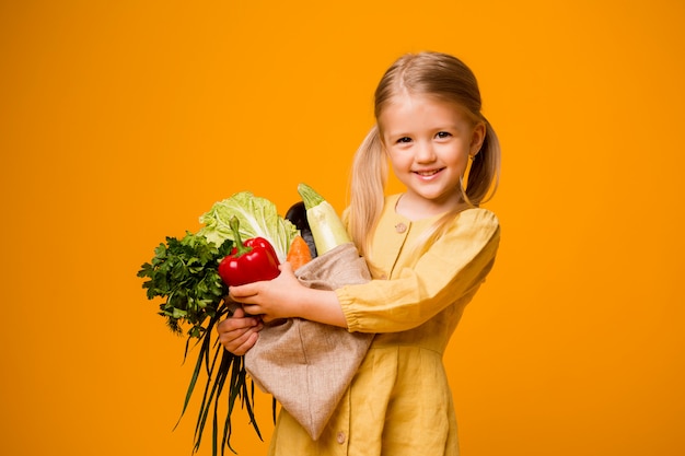 niña con bolsa ecológica y verduras