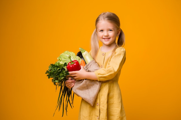 niña con bolsa ecológica y verduras