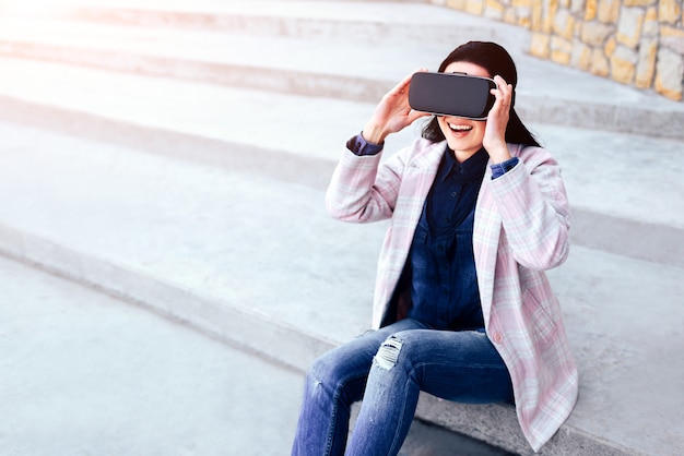 Niña bonita al aire libre disfrutando de gafas de realidad virtual