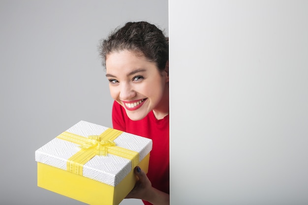 Niña bonita con una caja de regalo