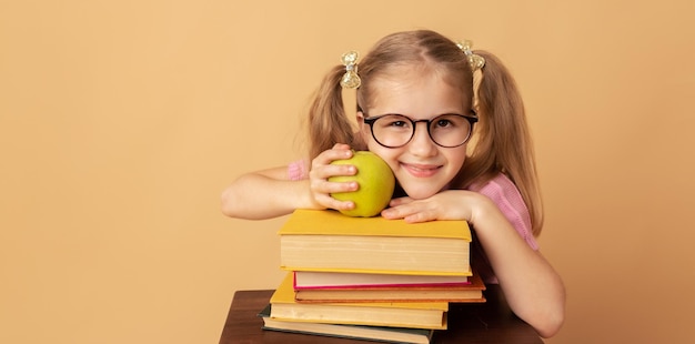 Niña bonita colegiala con libros y manzana Concepto de escuela Regreso a la escuela Día mundial del libro