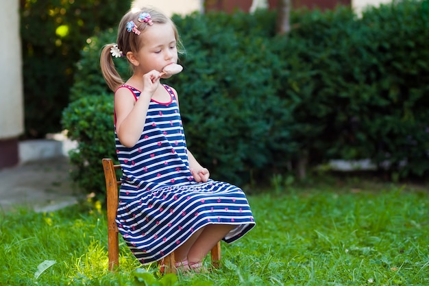 Niña bonita en día de verano comiendo un helado