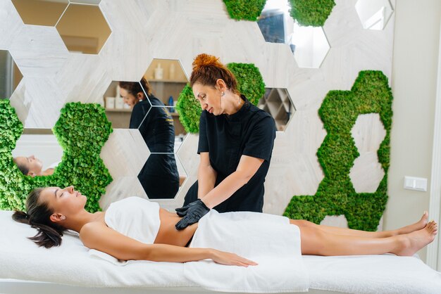 Una niña bonita está disfrutando de un masaje cosmetológico profesional en el Spa