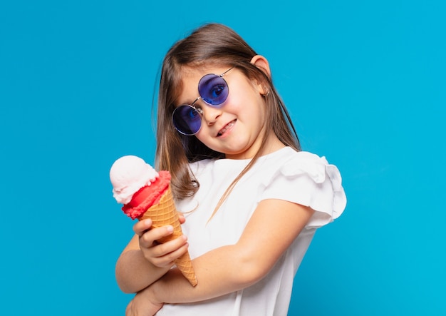 Niña bonita expresión feliz y sosteniendo un helado