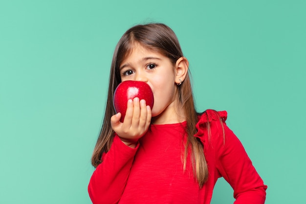 Niña bonita expresión feliz y sosteniendo una manzana