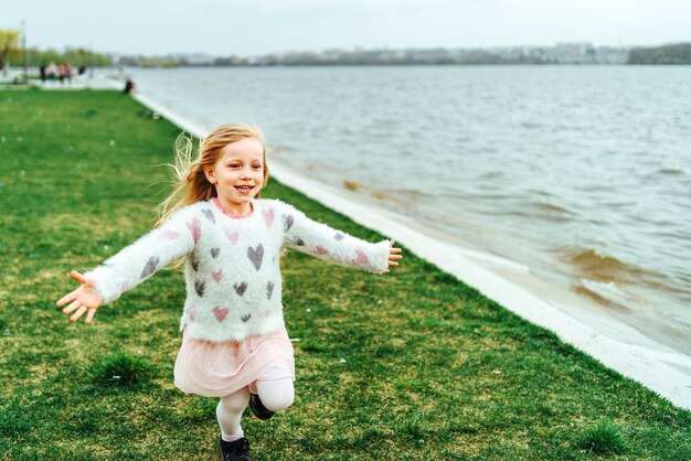 La niña bonita feliz se divierte en el parque