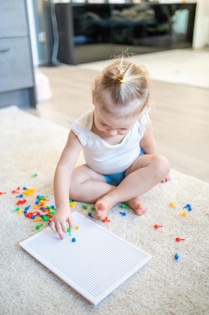 Niña bonita jugando con mosaico de uñas de setas en el hobby de casa y el tiempo libre