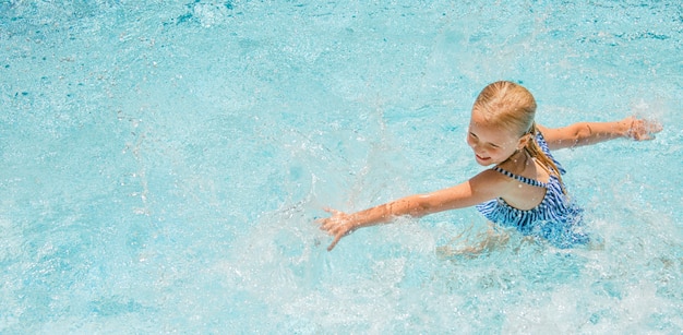 Niña bonita en la piscina, vacaciones de verano.