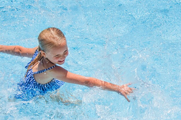 Niña bonita en la piscina, vacaciones de verano.