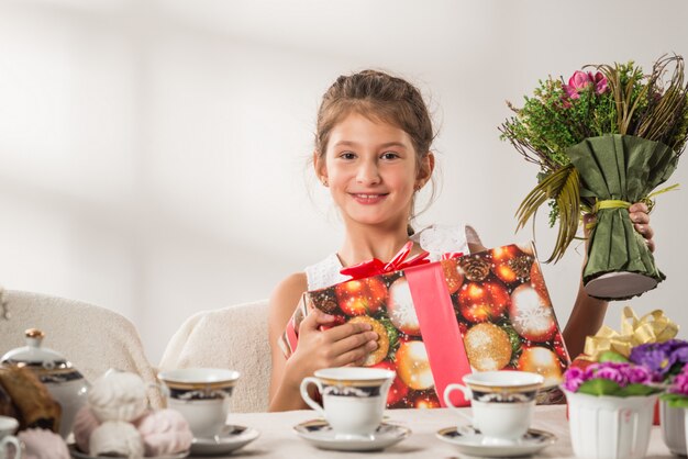 Niña bonita positiva con regalo de año nuevo