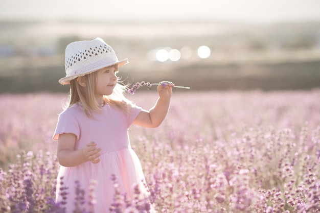 Foto niña bonita que huele a flor de lavanda