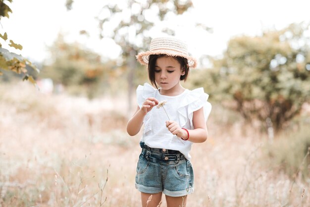 Niña bonita con ropa de verano y sombrero con flor