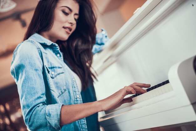 Foto niña bonita está tocando el piano en la tienda de música